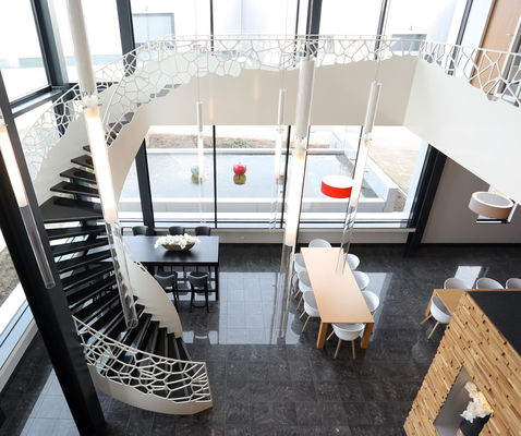 Escaleras curvadas edificio de mármol moderno con la barandilla estética de la escalera del hierro